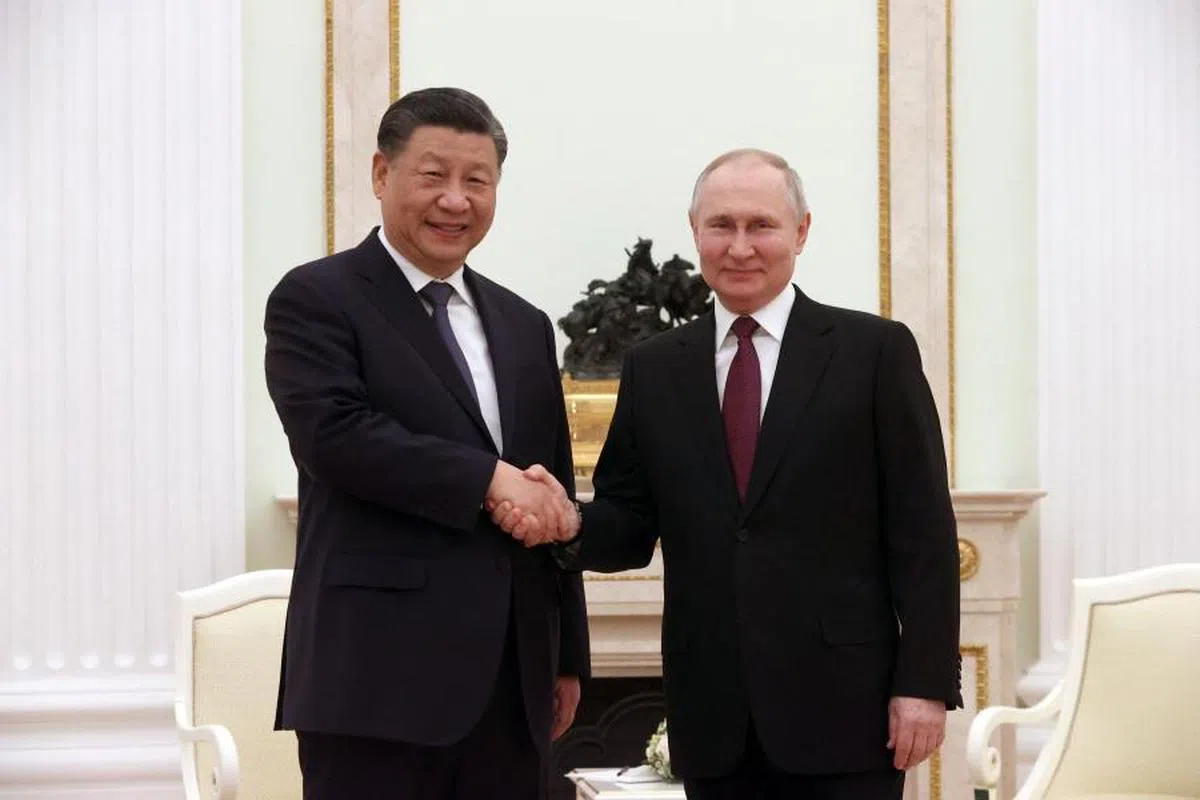 握手时，习近平（左）的手保持在普京（右）的上方。（法新社）