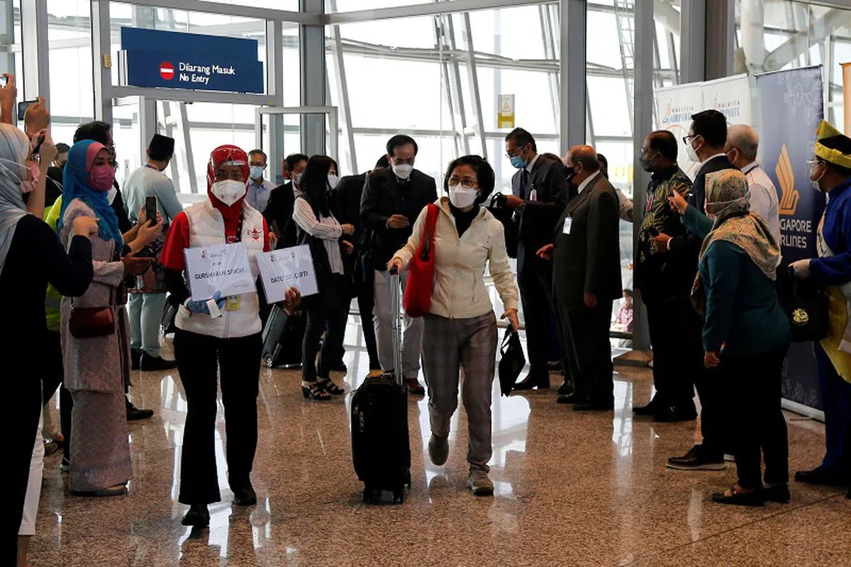 在新马空中疫苗接种者旅游走廊（VTL）计划下抵达吉隆坡国际机场的旅客。（路透社）