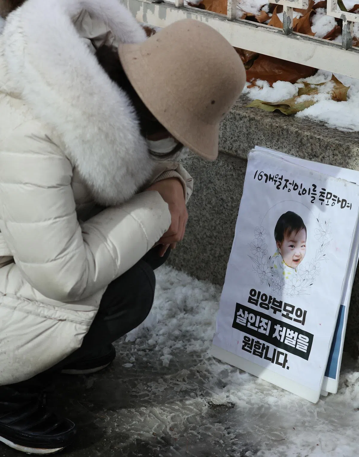  一名妇女在首尔南部地方法院外哀悼受害者郑仁。（韩联社） 