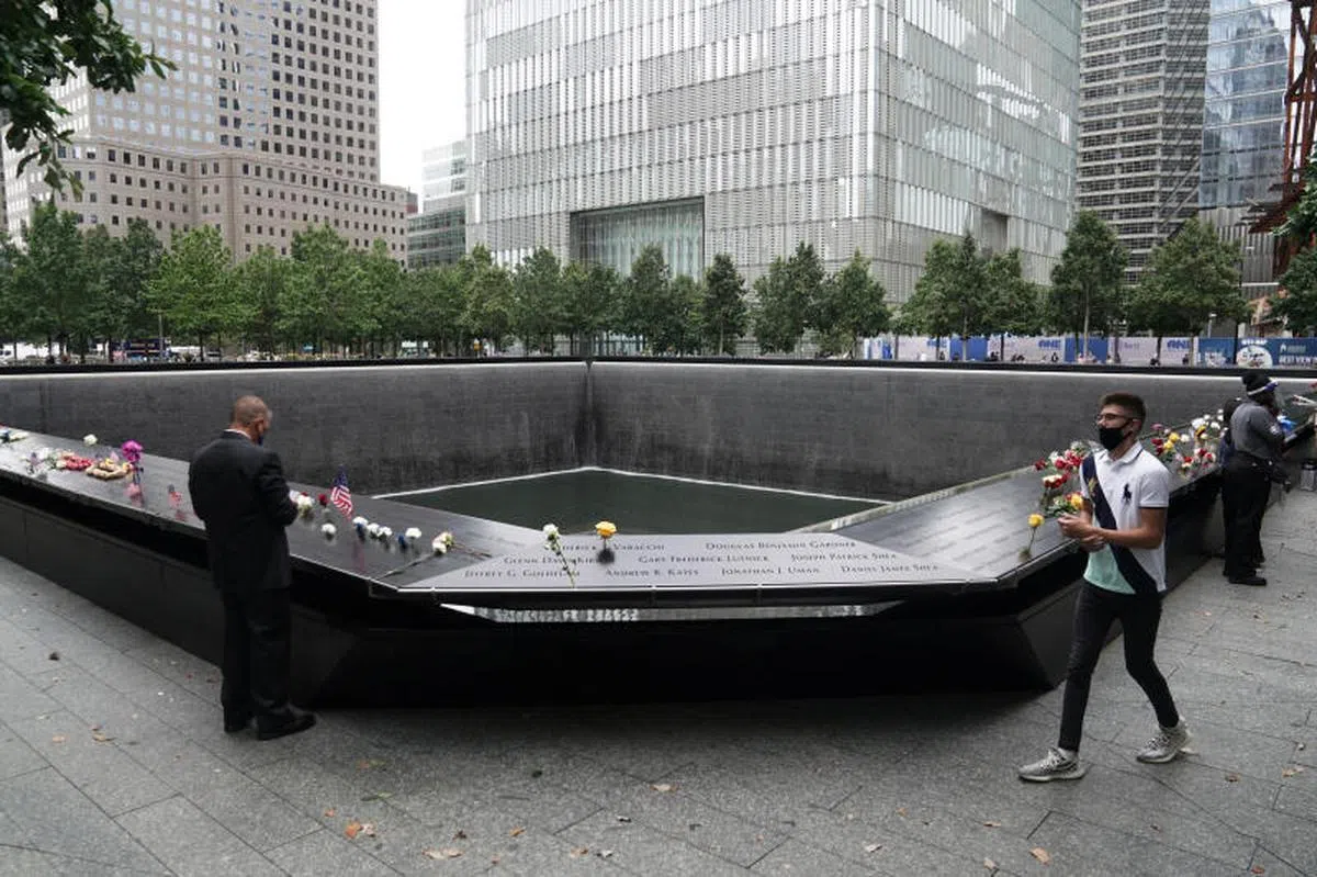  今年9月11日，人们在纽约市911国家纪念博物馆献花，为死于911恐怖袭击的人们默哀。（法新社） 