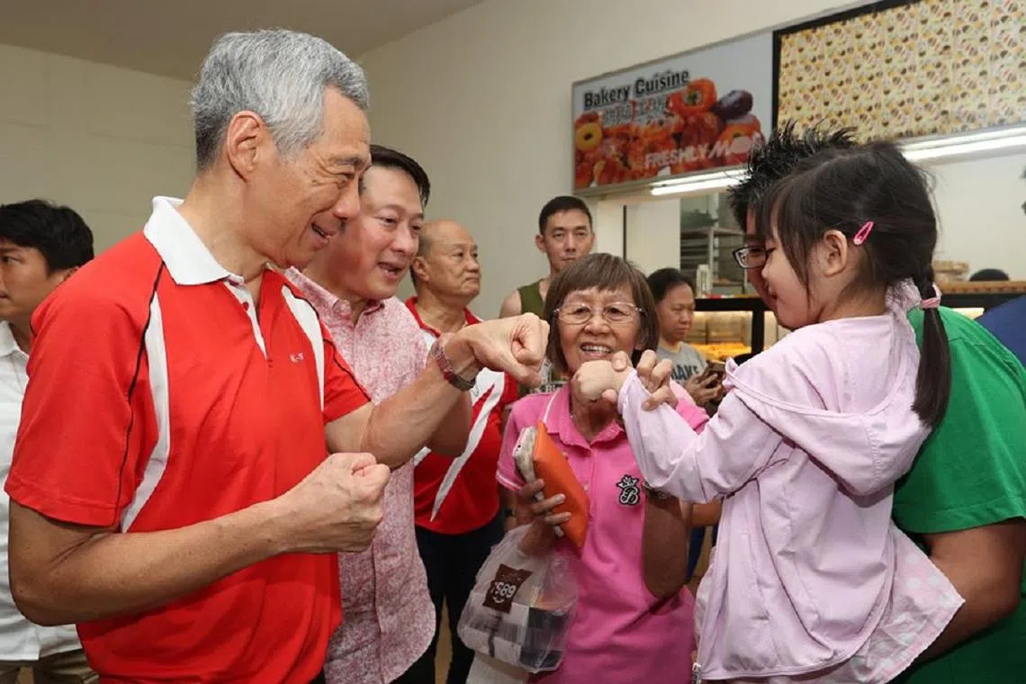 李显龙总理周末走访最新划分的盛港集选区内的实里达购物中心时，与小朋友用“碰碰拳”的别致方式来打招呼。（李显龙面簿）