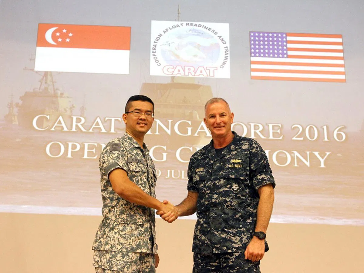  代号“ 联合备战与训练”（Cooperation Afloat Readiness and Training Exercise，简称CARAT）的新美海军大规模演习于2016年7月19日展开，为期约两周。时任新加坡海军舰队司令柳俊泓准将（左）与美国西太平洋后勤群指挥部第73特遣队指挥官赫尔利（Brian Hurley）少将在樟宜海军基地主持CARAT演习开幕仪式。 （联合早报） 