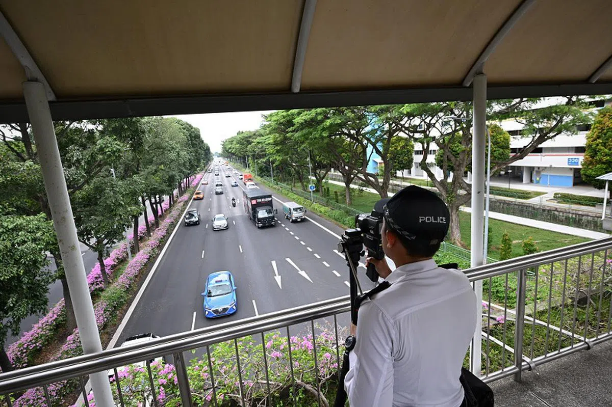 专家表示，跨分道线行驶确实应该被禁止，但除非能在公路上增加人手监察是否有骑士违例，否则应不太可能有效执行。图为交警捉拍超速驾驶的行为。（海峡时报）