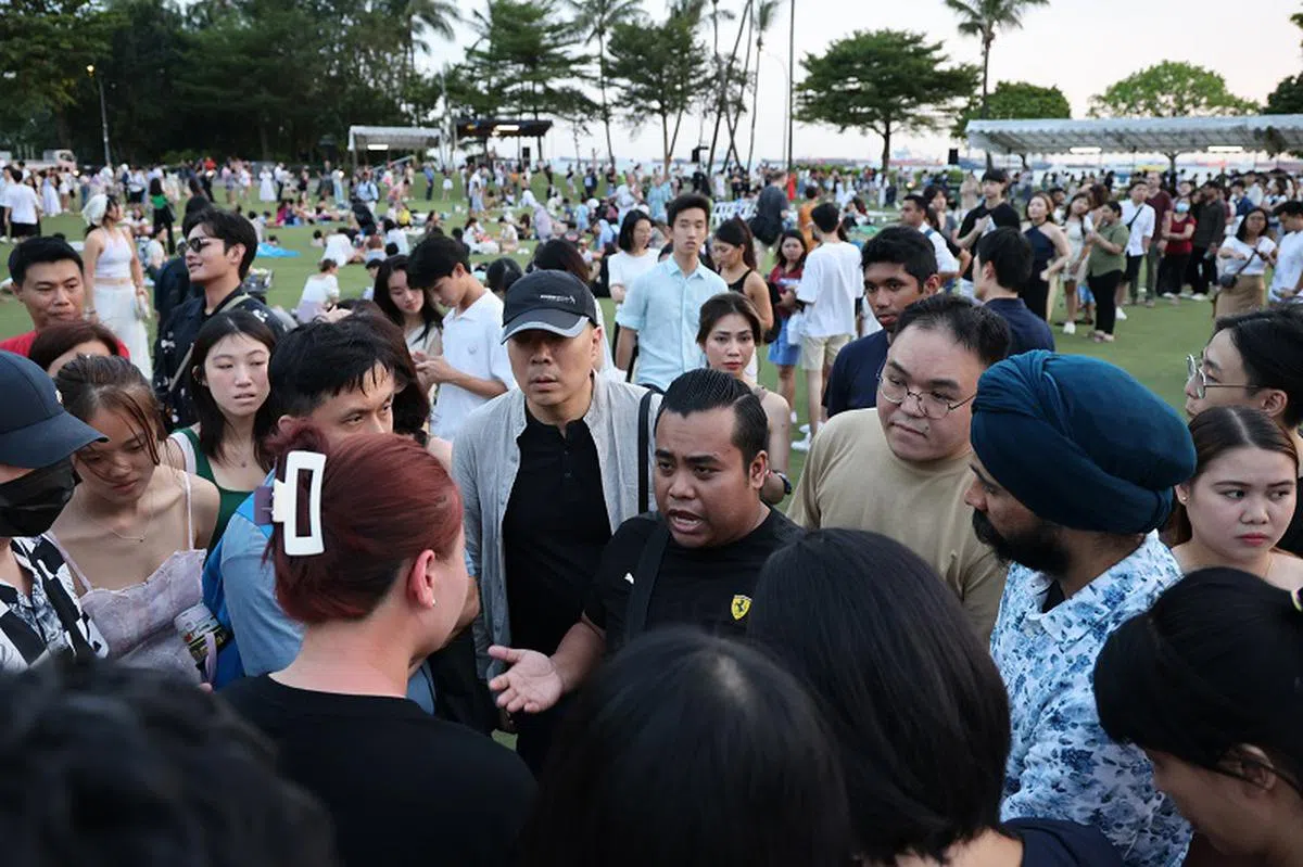 至少2500人购票参与天灯节活动。图为活动参与者与主办方代表了解情况。（海峡时报）