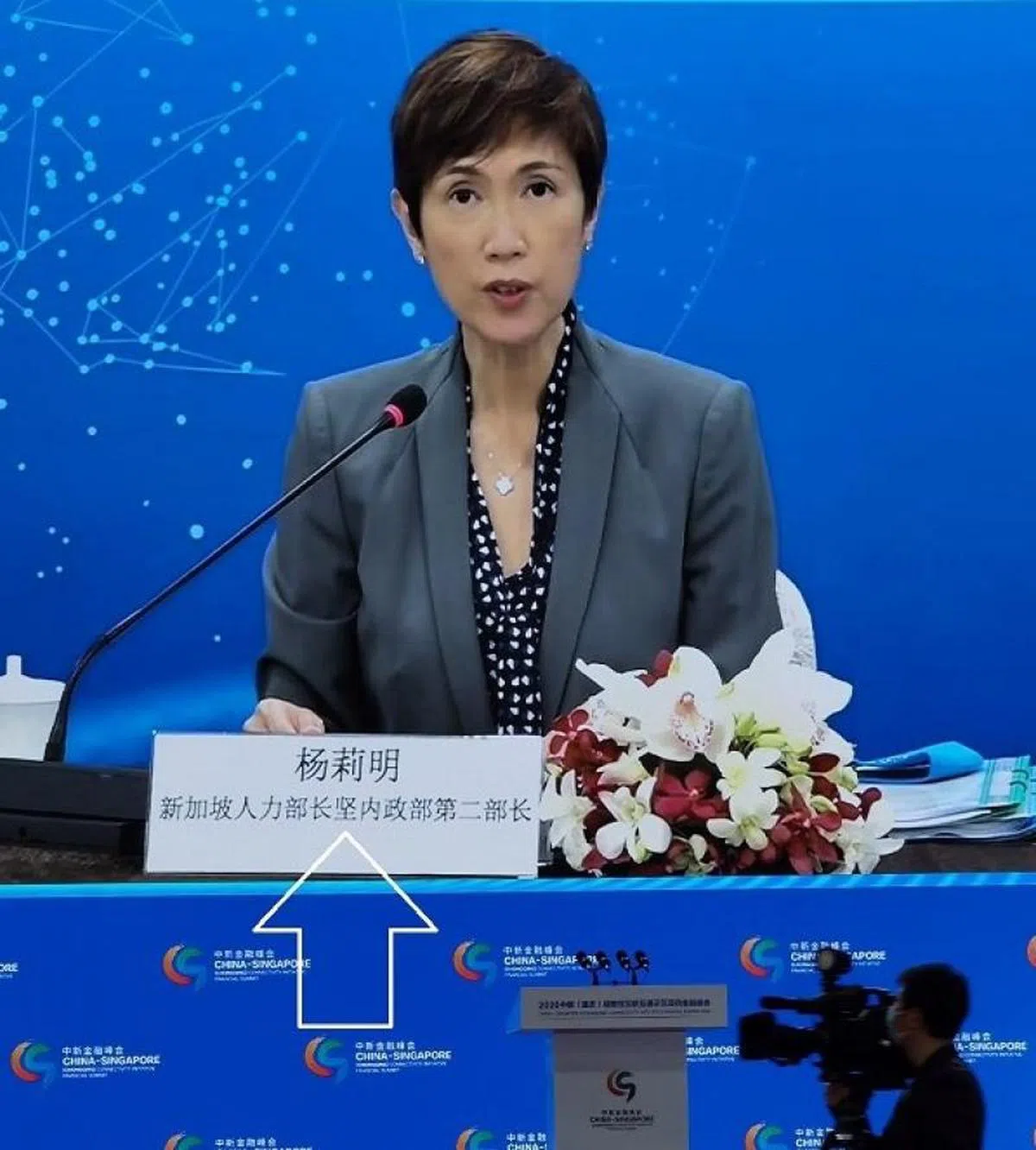  写着杨莉明职衔的牌子出现中文字错误，“兼”字被误写成“坚”。（互联网） 