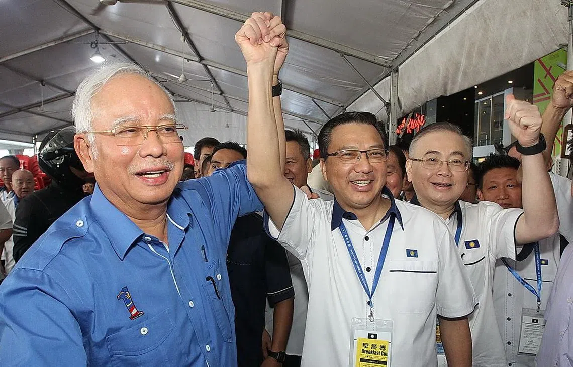 马华第63届中央代表大会上，马来西亚首相纳吉（左）高举马华总会长廖中莱右手，借此强调国阵成员党永远团结一致。（联合早报）