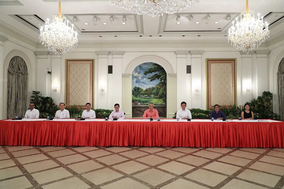  总统府直播记者会。左起：即将任卫生部兼通讯及新闻部高级政务部长的普杰立、新任总理公署部长的陈诗龙、转任国家发展部长的李智陞、副总理兼财政部长王瑞杰、李显龙总理、贸工部长陈振声、升任总理公署部长的孟理齐以及出任政务部长的新人颜晓芳。（通讯及新闻部提供） 