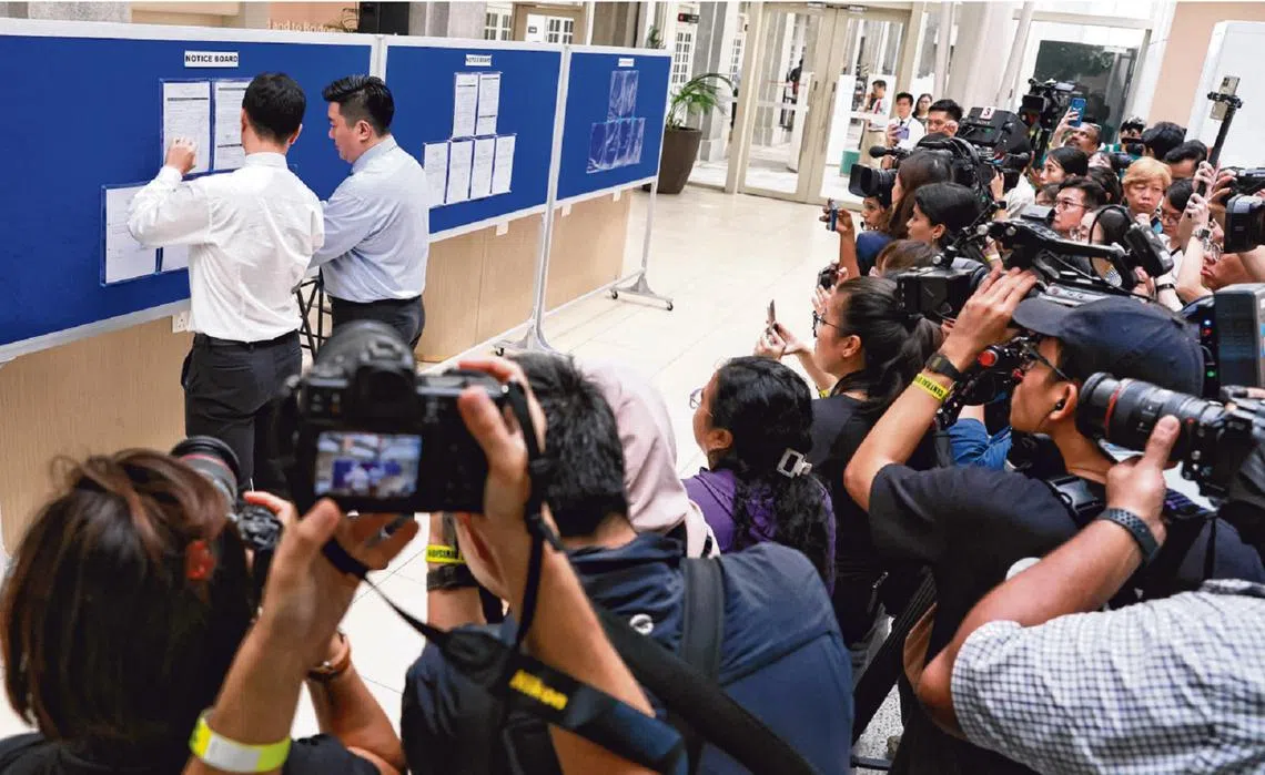 提名日当天，选举局工作人员将三名准候选人所提交的资料贴在布告板上。（海峡时报）