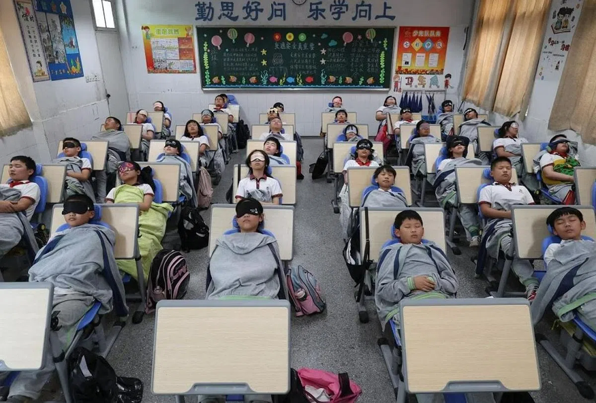 中国小学生躺在折叠椅上睡午觉，有助提升学习能力和记忆力。（人民日报脸书）