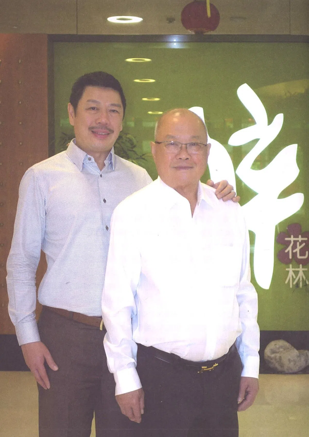  黄南德（右）和大儿子黄建铭。（《新加坡潮人故事》） 