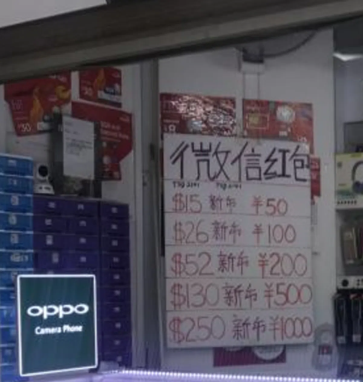  爆料的公众所提供的照片显示，大大的微信红包“汇率版”就悬挂在手机店内，十分醒目。（新明日报） 