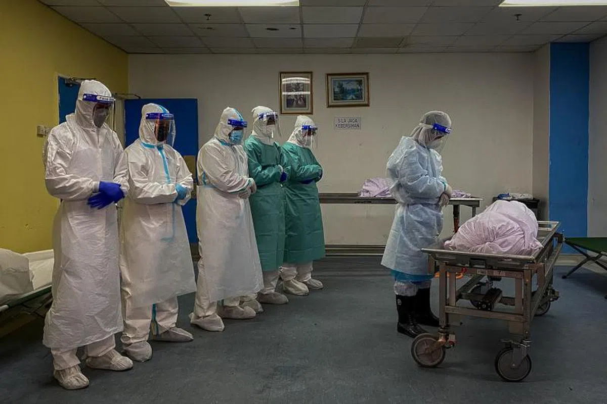  相关人员正在为一名冠病死者进行祷告仪式。（海峡时报） 