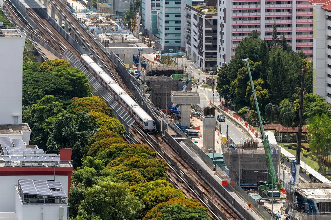 在武吉巴督，一列川行的地铁列车经过正在建造的裕廊区域地铁站。（联合早报）