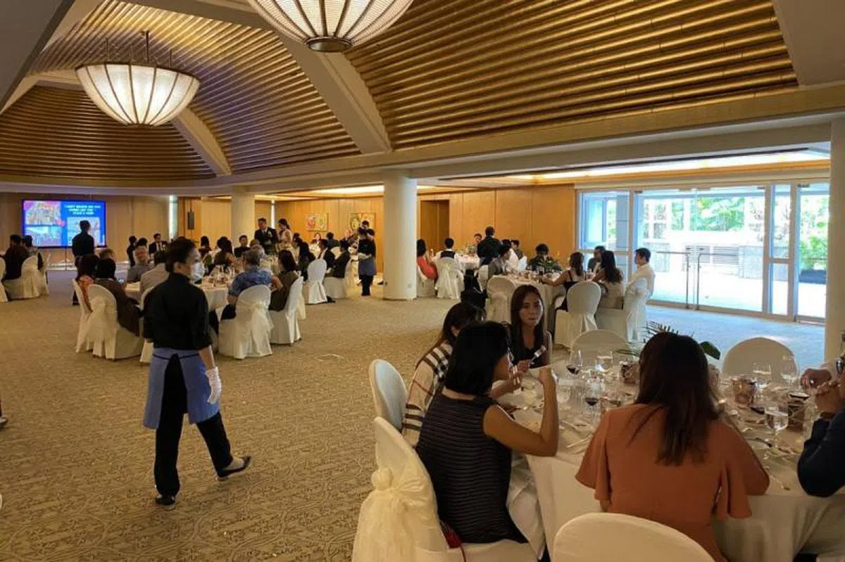  3月21日在丽思卡尔顿美年酒店（The Ritz-Carlton）的一场婚宴。可见宾客们之间的距离都被拉大，且工作人员也都戴上了口罩与手套。（海峡时报） 