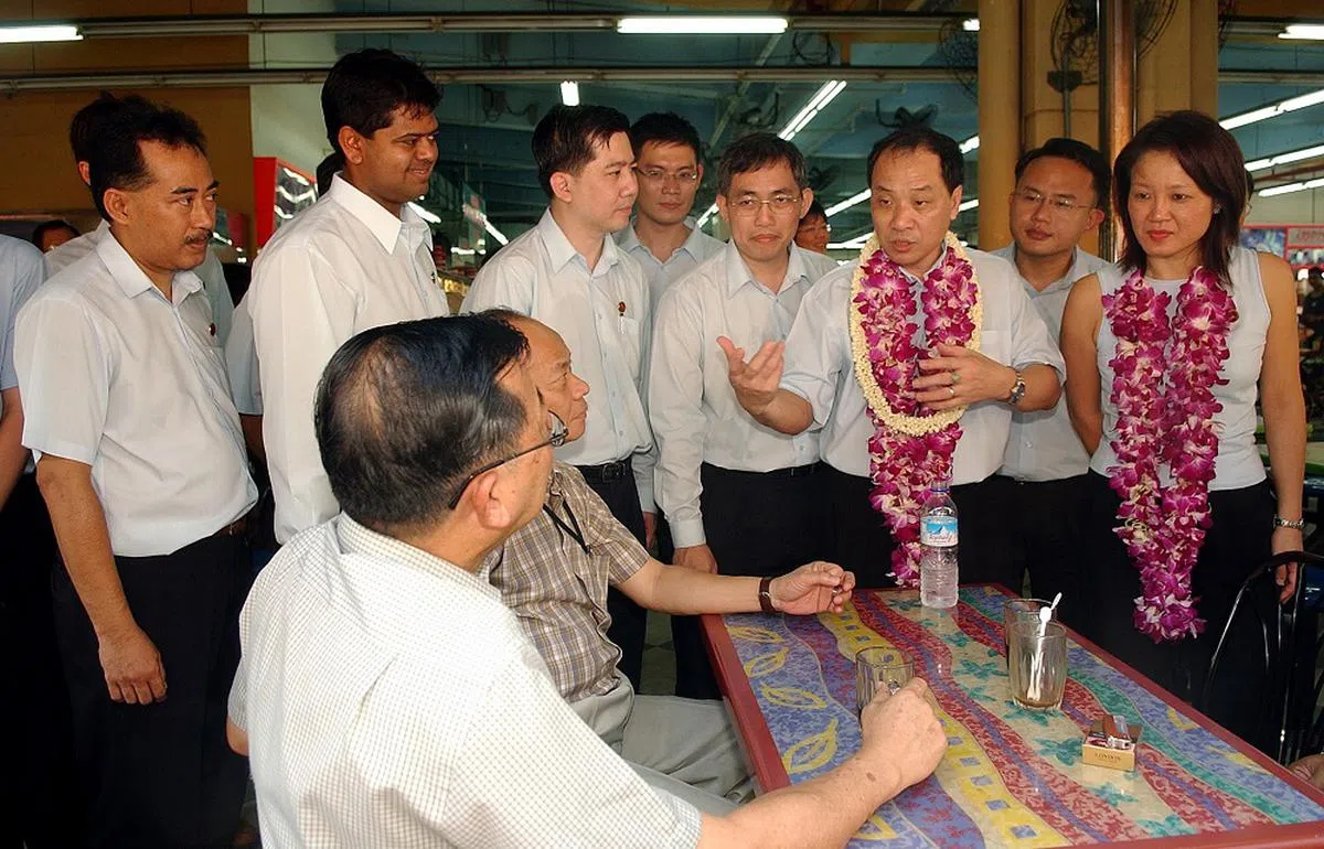 2006年大选竞选期间，林瑞莲（右一）和吴明盛（右四）在刘程强（右二）的带领下，与其他工人党候选人走访后港区。（海峡时报）