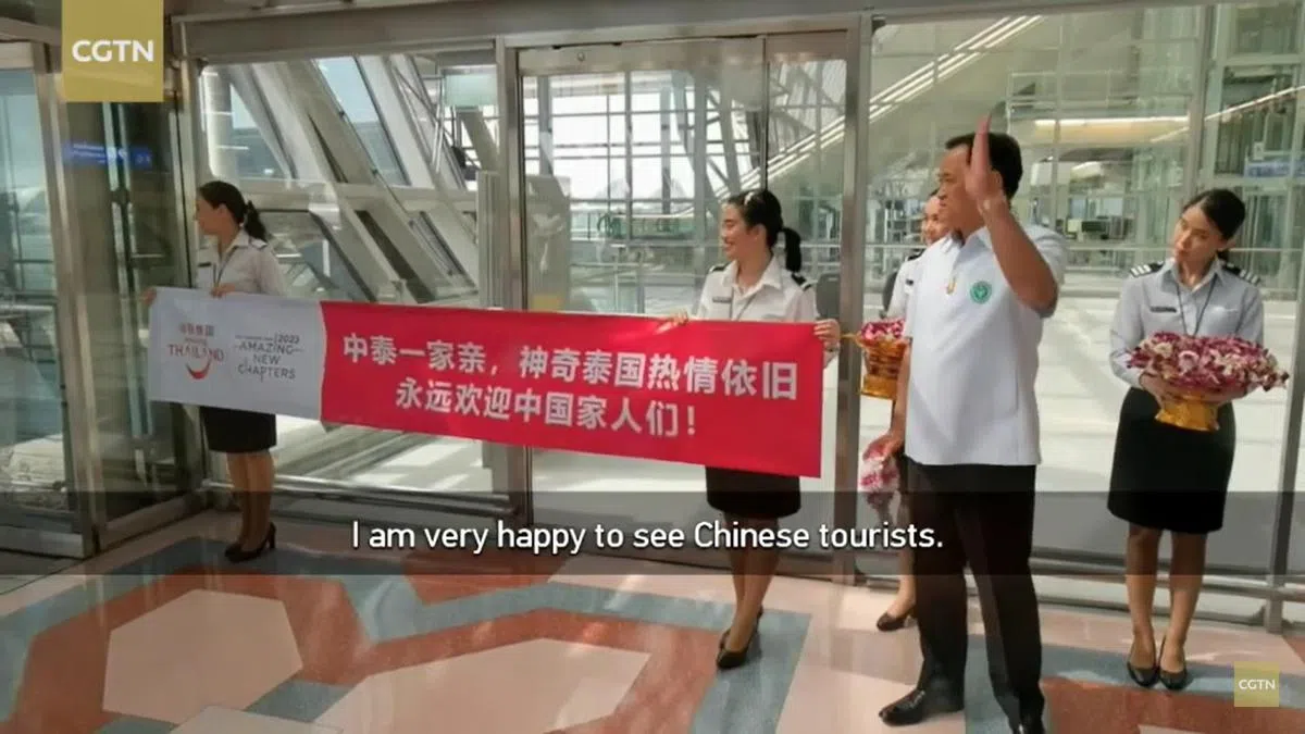 泰国副首相兼卫生部长阿努廷（右二）1月9日亲自到曼谷素旺那普机场迎接久违的首批中国游客。（CGTN视频截图）
