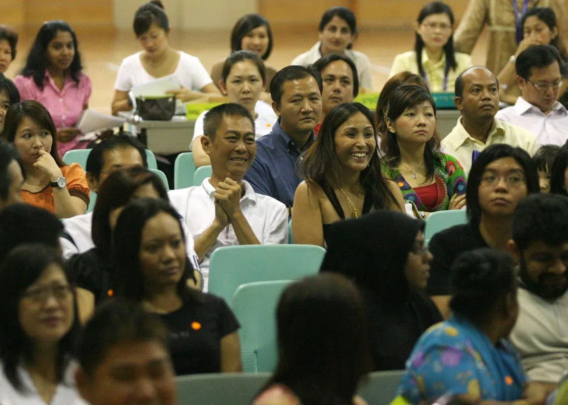 一对父母得知孩子被心仪的小学录取后，笑逐颜开。（联合早报档案照）