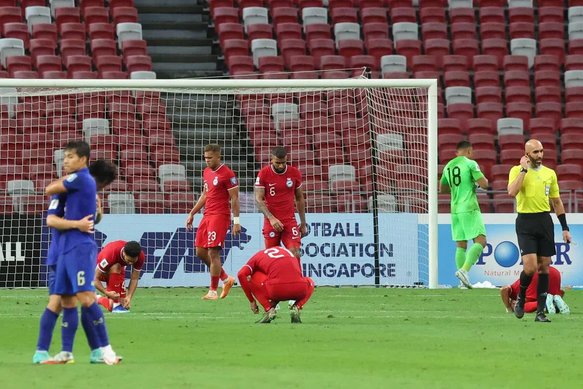 新加坡国家足球队“雄狮”于2023年11月21日在国家体育场以1比3不敌泰国队。泰国球员（蓝衣）在赛后庆祝胜利，新加坡球员（红衣）则显得失落。（联合早报）