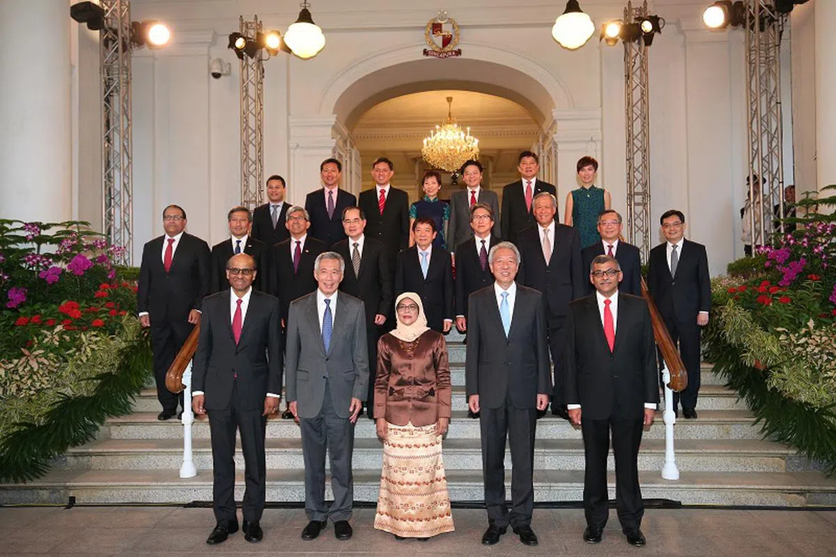  新加坡总理李显龙（左二）与内阁部长们去年在哈莉玛总统（前排左三）就职仪式上合照。（海峡时报） 