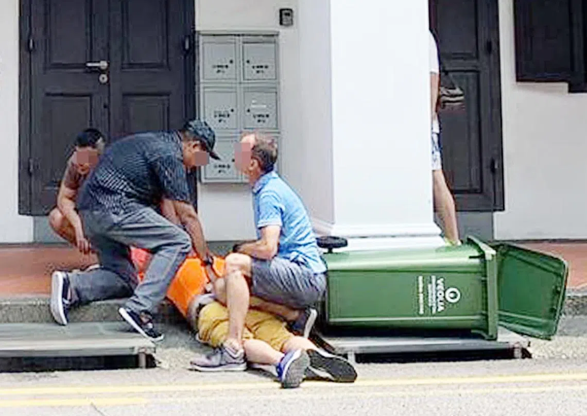 身材高瘦的洋汉一度单膝跪压着壮男的臀部，另外两名男子则分别在壮男的头部和身旁压制住他。（新明日报）