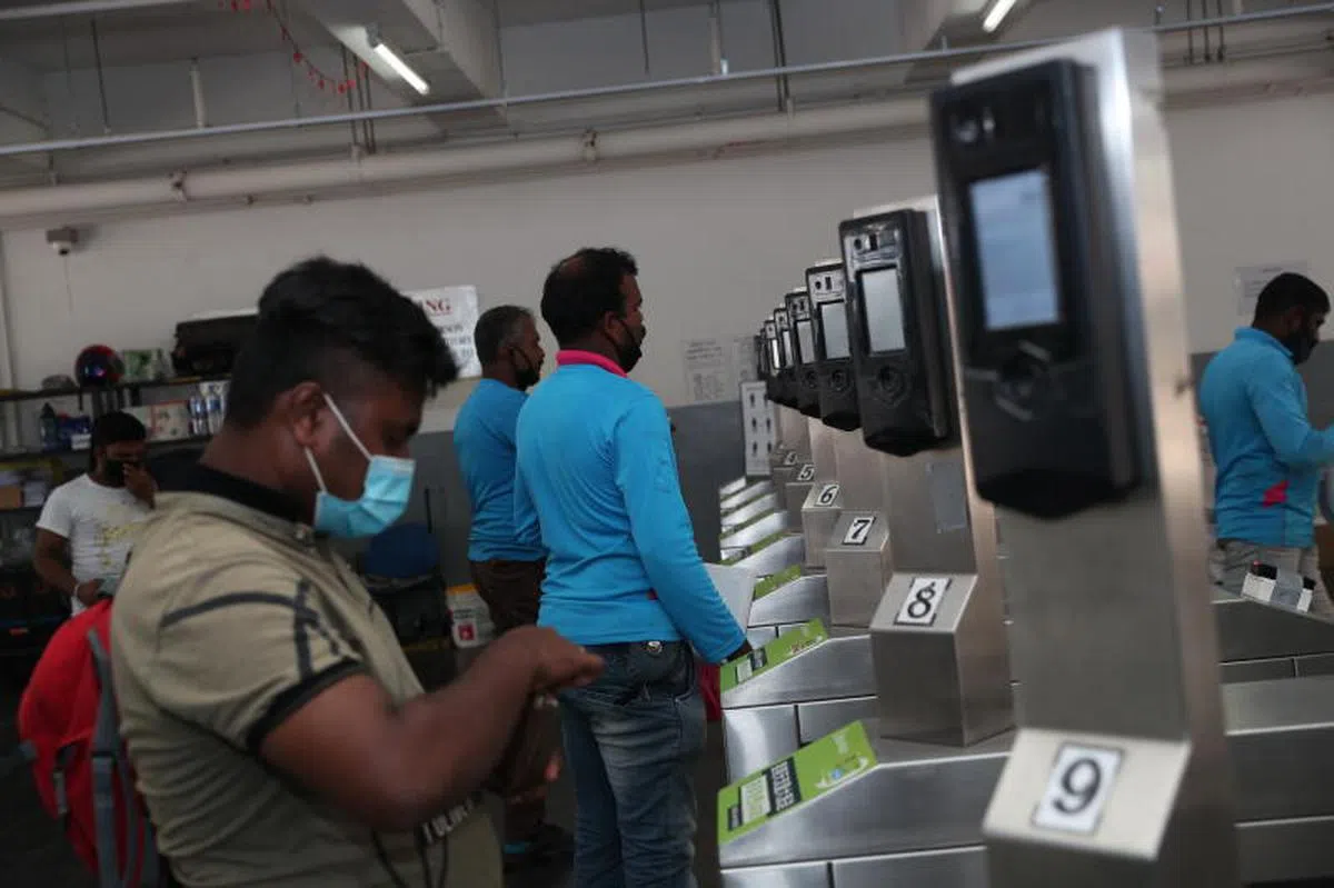  客工们每天傍晚回返宿舍时，都必须扫描脸部和指纹来“打卡”。（海峡时报） 