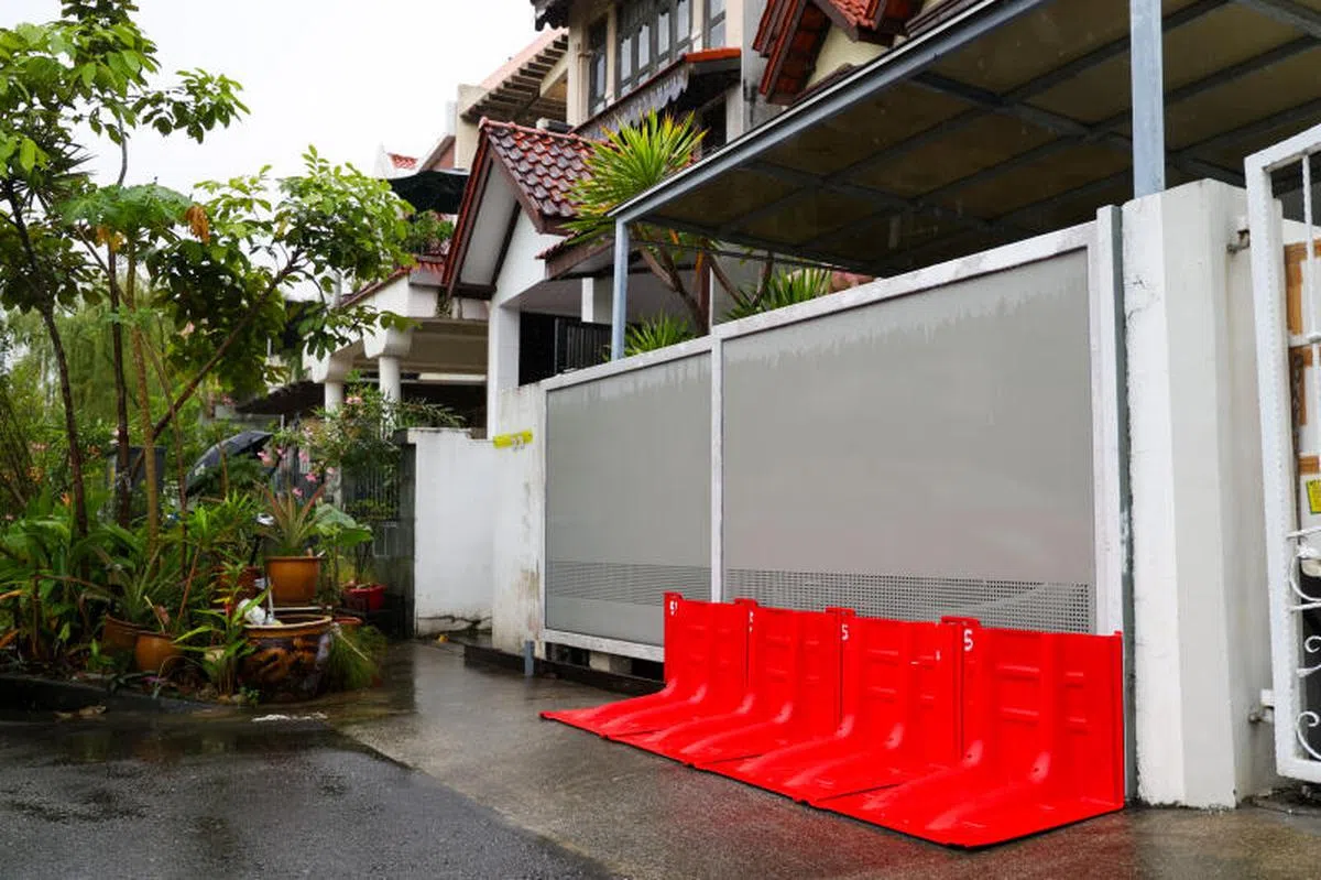 过去两天雨水连绵不断，在地势较低的剑桥路（Cambridge Road），1月11日有地住宅的居民在门外架起挡水栏，以防积水流进屋内。（联合早报）