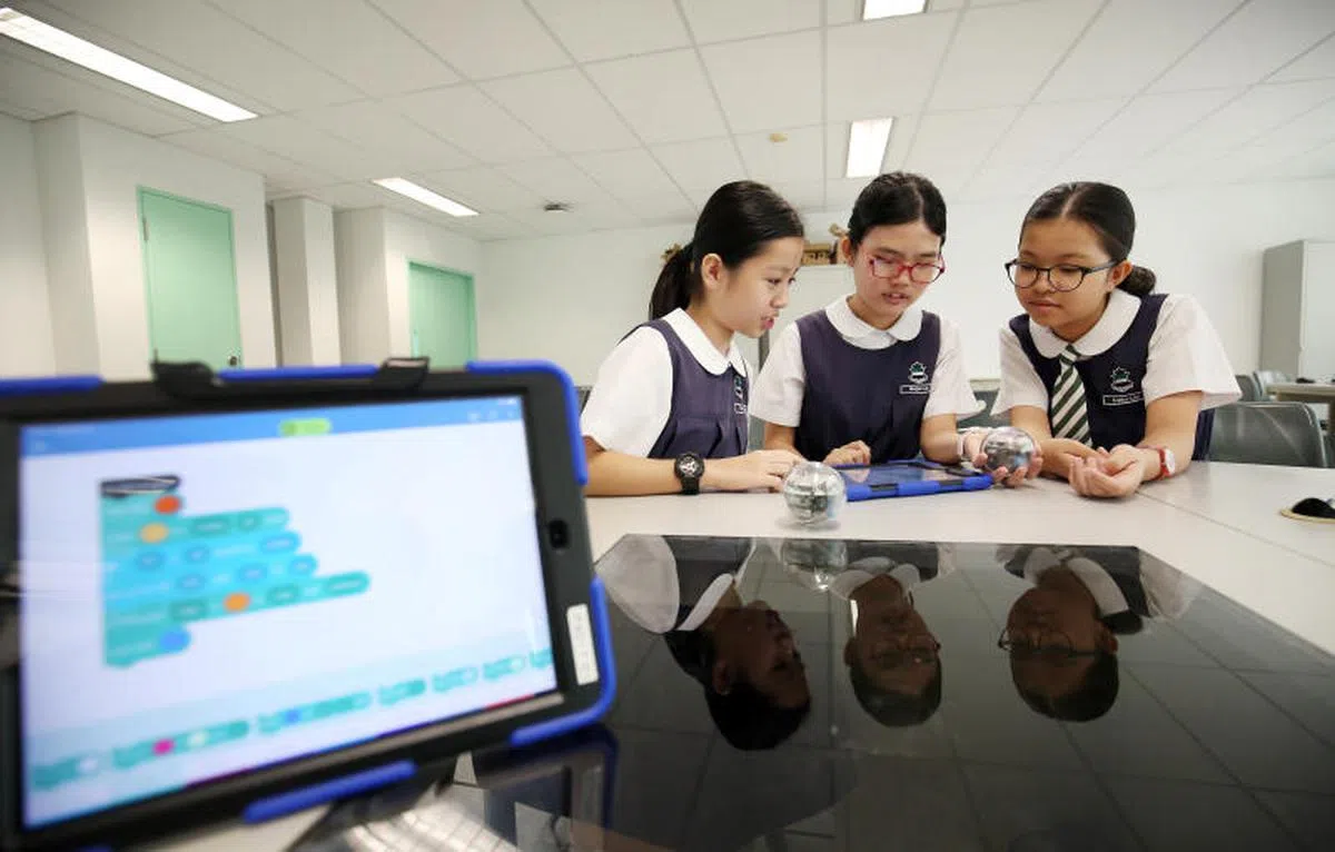  2020年起，新加坡所有四年级至六年级的小学生都必须在学校参与长达10小时的编码增益课程，培养计算思维能力。图为莱佛士女子小学的学生学习运用编码工具操作机器球。（联合早报） 