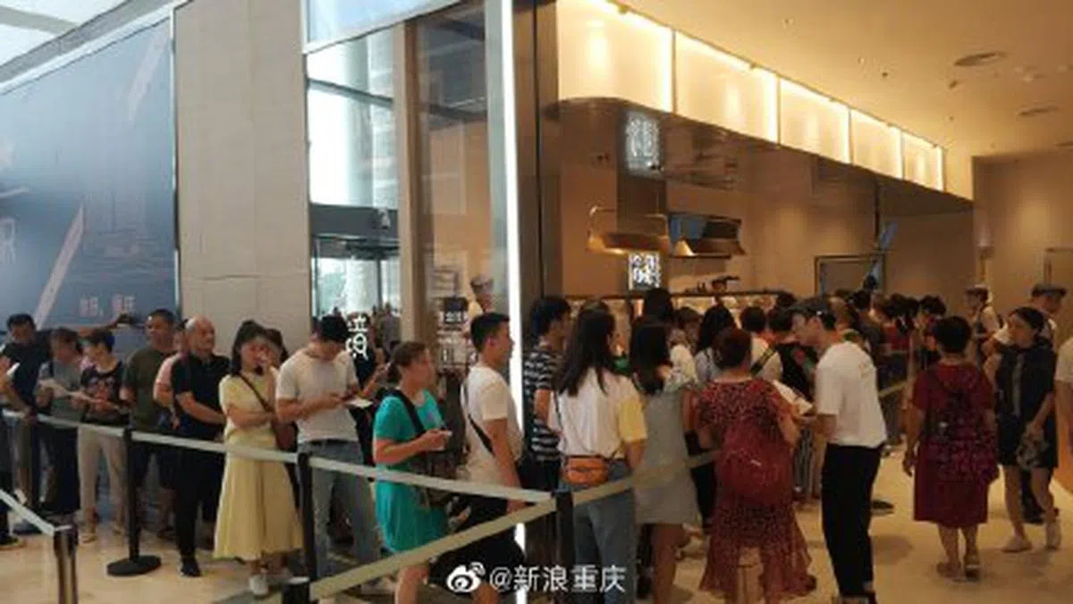  人们跟着队伍排队等待进入餐厅用餐。（新浪重庆微博） 