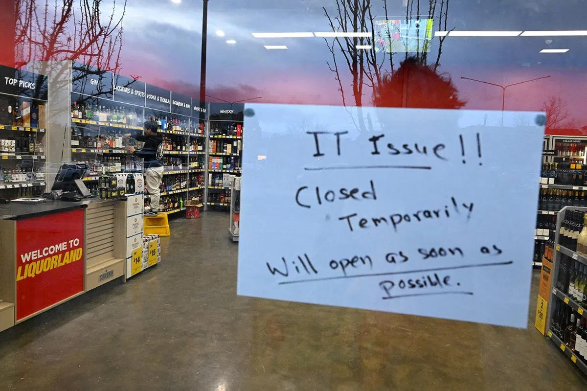 这家酒精饮品店的老板直接在玻璃门上张贴告示，告诉顾客他们由于技术问题暂时关店，但会尽早恢复营业。（路透社）