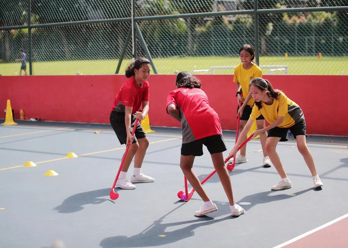 中学生参与地板曲棍球训练。（海峡时报）