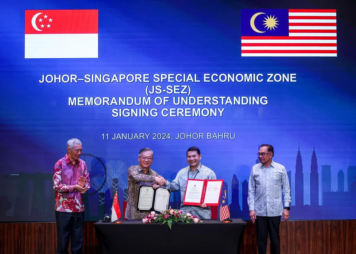 时任新加坡贸工部长颜金勇（左二）今年1月和马国经济部长拉菲兹（右二）在新山签署谅解备忘录。时任新加坡总理李显龙总理（左一）和马国首相安华在旁见证。（联合早报）