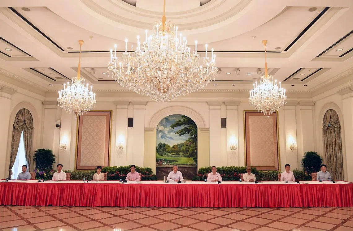 李显龙总理（中）与副总理兼经济政策统筹部长及财政部长王瑞杰（左四）4月8日在总统府召开记者会，宣布王瑞杰从新加坡第四代领导团队同侪之首的位置退下。（海峡时报）