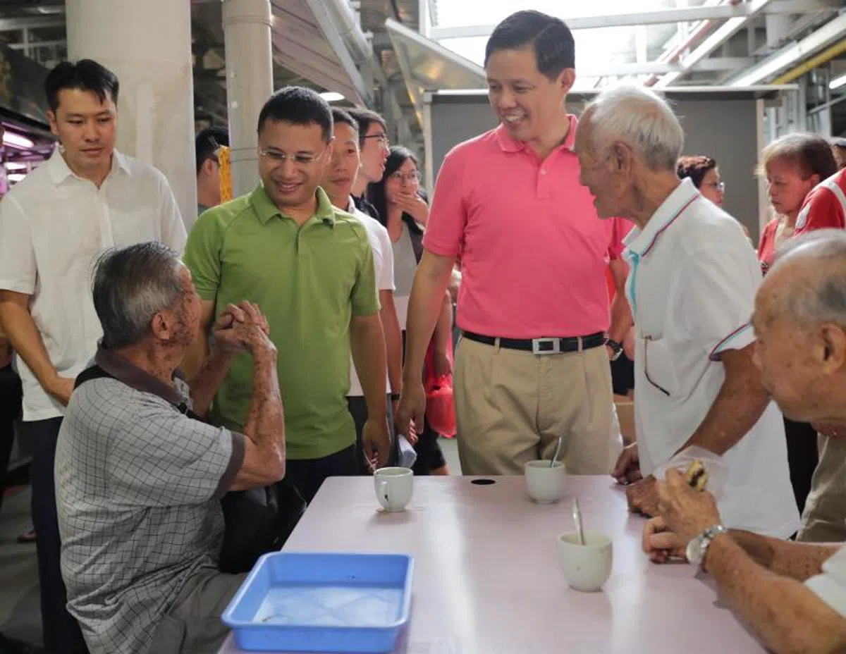  贸工部长陈振声（右二）和社会及家庭发展部长李智陞（左二）昨天走访裕泉区的湿巴刹和咖啡店等，了解居民对新冠病毒疫情以及抢购囤货等方面的想法。居民见到部长，以抱拳方式取代握手打招呼。 （海峡时报） 