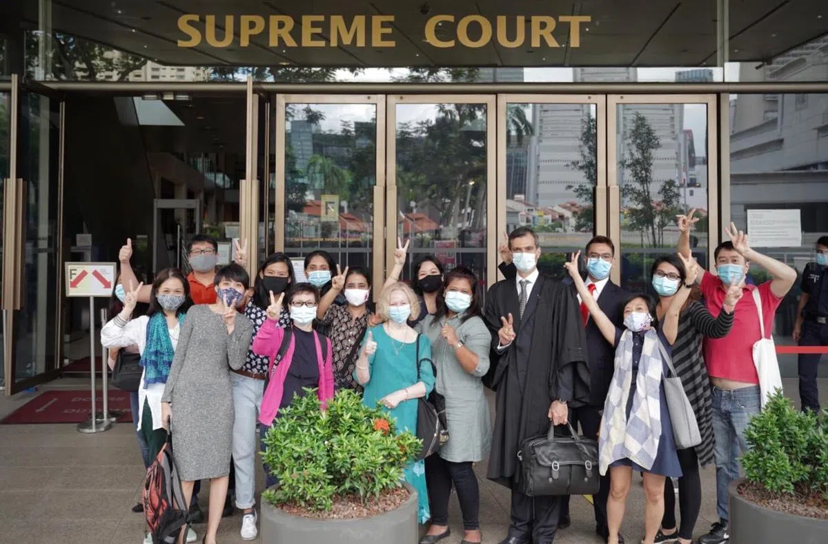  洗脱罪名的莉雅妮（前排左四）与情义之家的成员，以及辩护律师阿尼尔（前排右二）在高庭外合照。（情义之家面簿） 