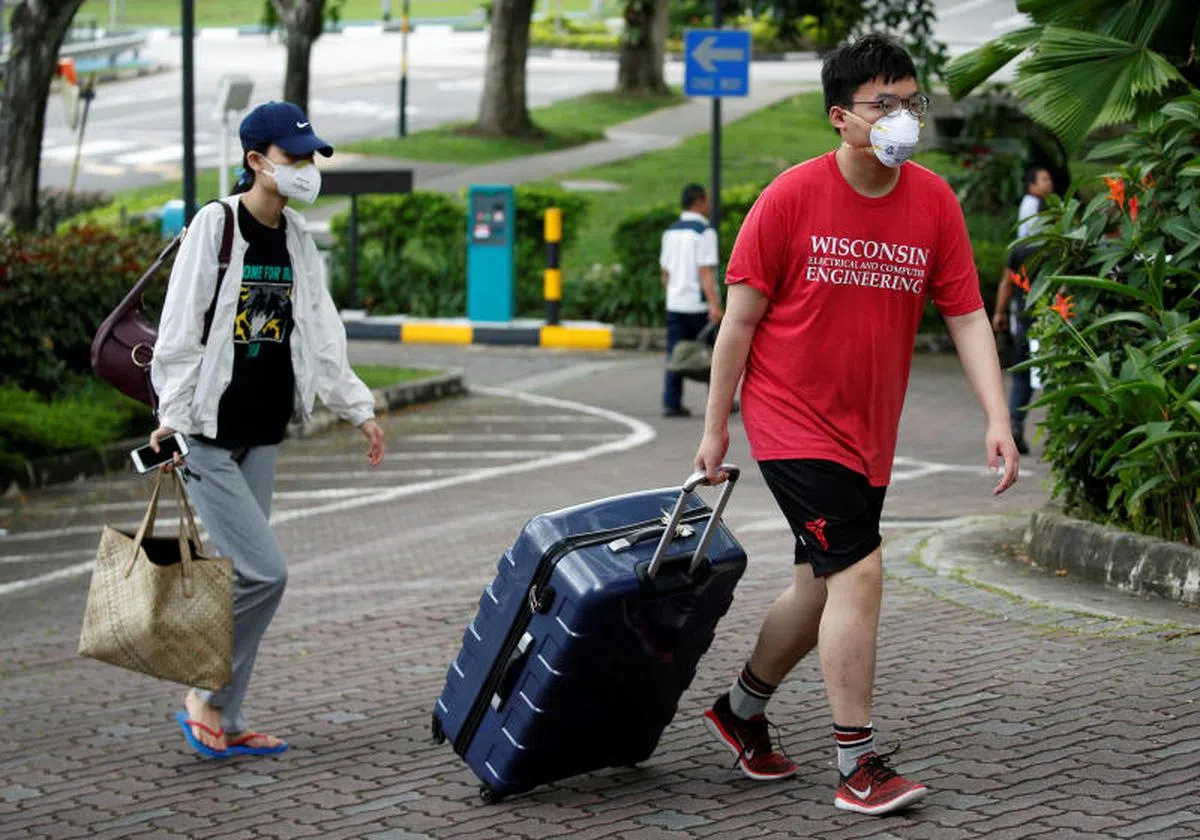  过完春节从中国回返新加坡的大学生直接拉着行李从机场直奔南洋理工大学的宿舍进行隔离或休缺席假。（路透社） 