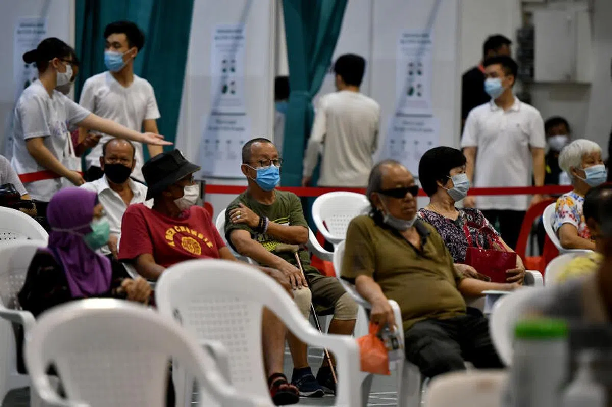  在丰加北民众俱乐部等待接种莫德纳冠病疫苗的国人。（海峡时报） 