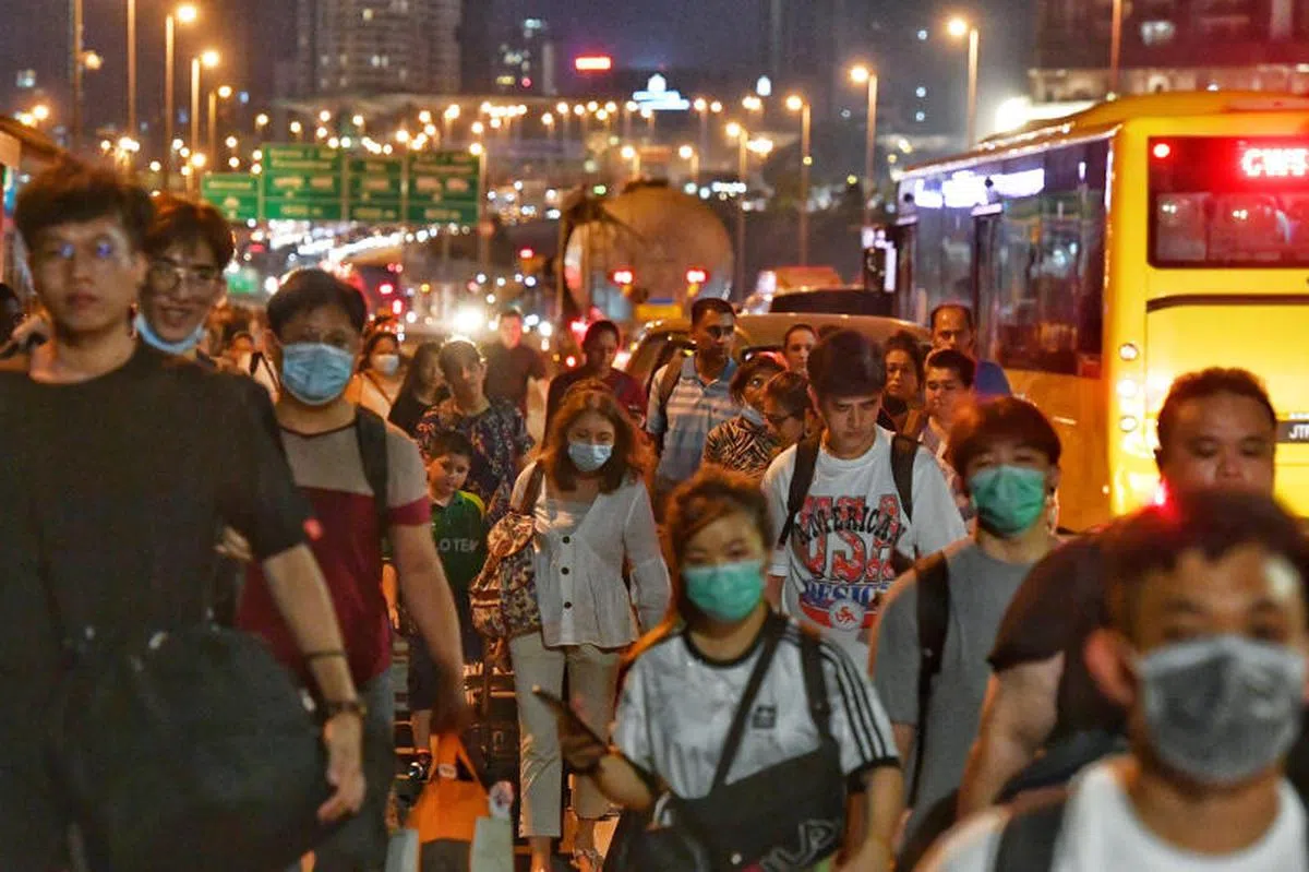  每天越过长堤来上班的马国客工。（海峡时报） 