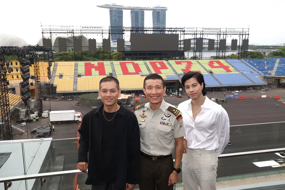 国庆庆典执行筹委会今天举行记者会。图为国庆主题曲MV的其中一位导演顾加民（左起）、国庆庆典执行筹委会主席刘伟胜准将，以及今年负责演唱国庆主题曲的本地歌手金文明。（联合早报）