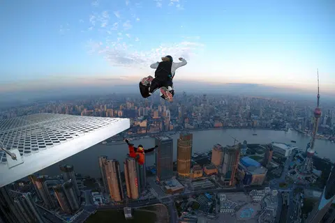 欧美国家流行的一种近乎玩命的“运动”，叫做低空跳伞（BASE jumping）。图为在中国上海开展的低空跳伞活动。（维基百科）