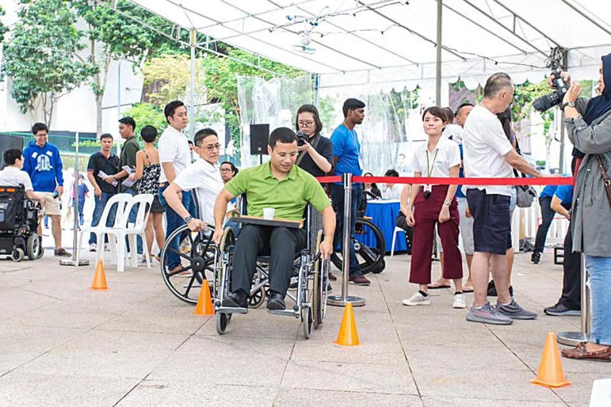  今年9月，李智陞出席MDAS Live Above Carnival，并体验坐轮椅完成运动项目。（联合早报） 