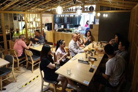 在日本餐馆，一群同事一起吃饭庆祝生日。（联合早报）