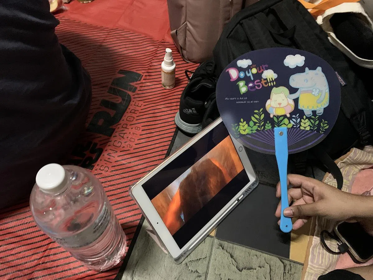 边扇风边看影集，才不会觉得闷热，时间也过得比较快。（红蚂蚁摄）
