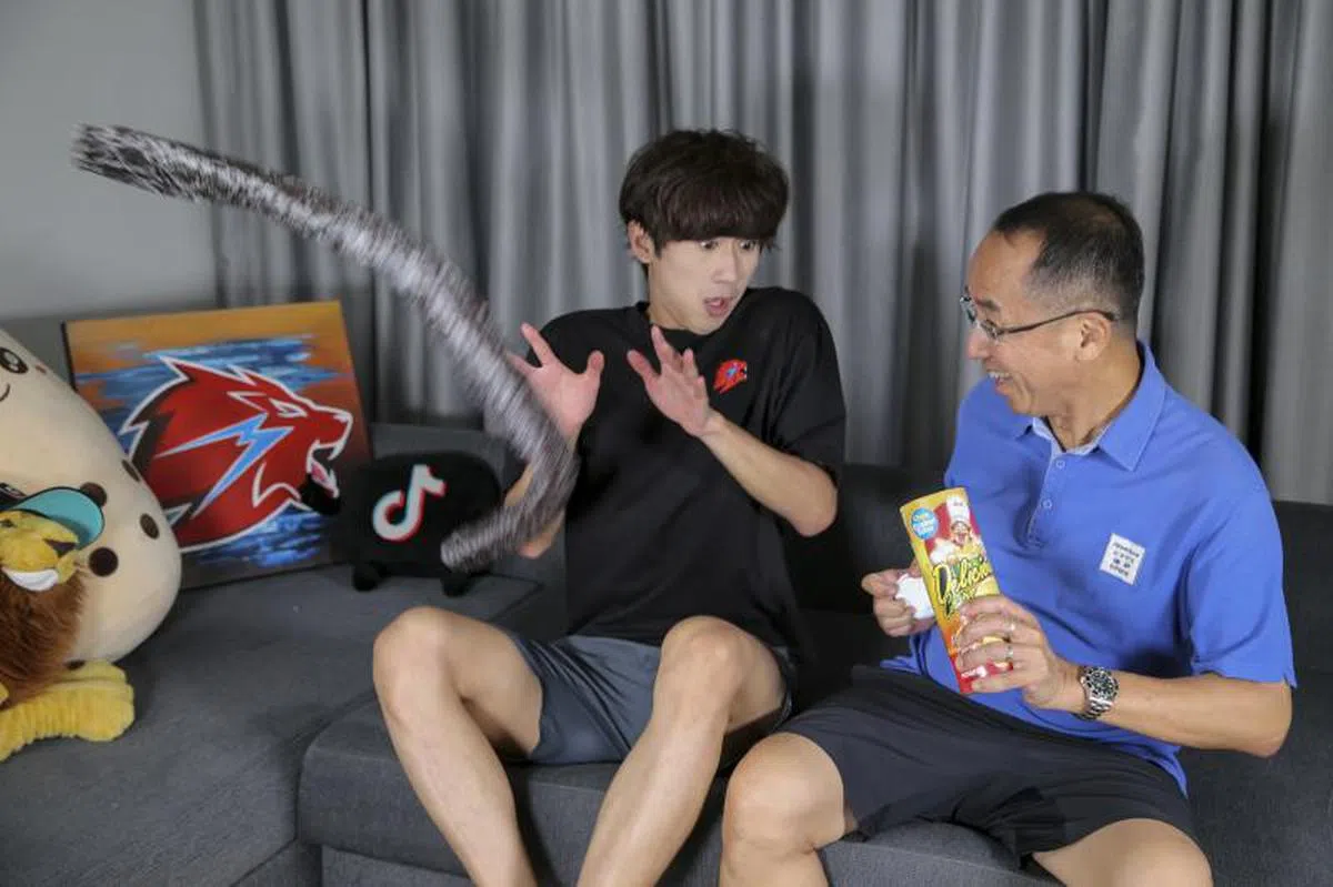  黄名纬（左）和他爸爸在社交平台上发布的趣味短片深受欢迎。（海峡时报） 