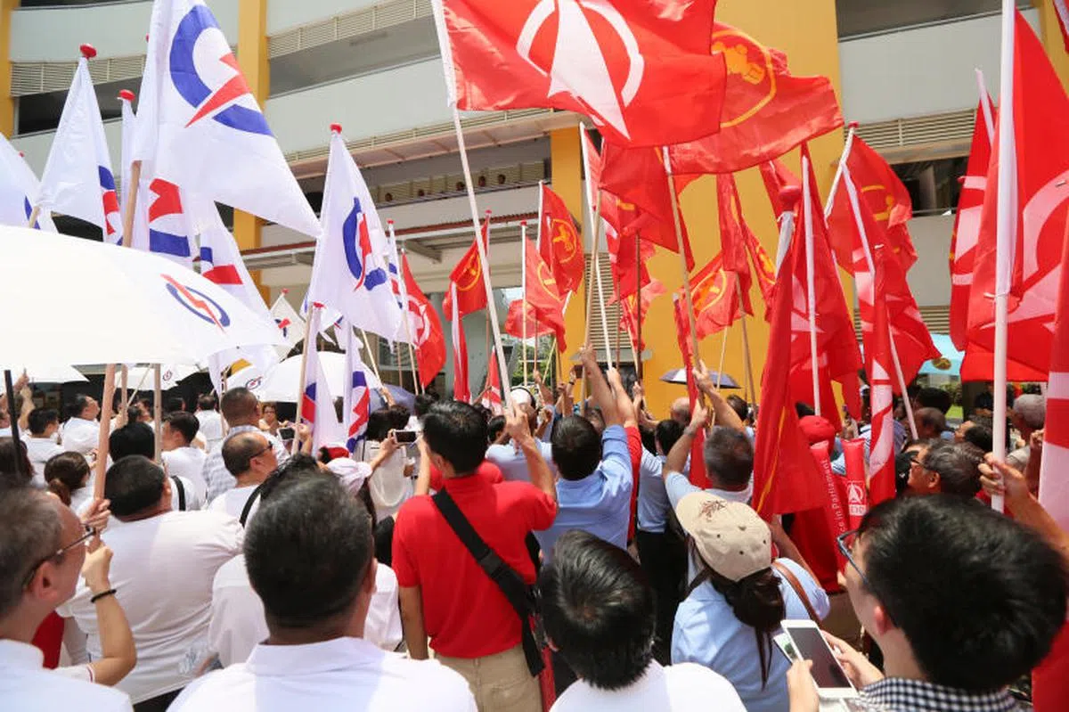  2015年，新加坡民主党（右）与人民行动党（左）的旗帜在提名站外“拼高下”。（联合早报） 