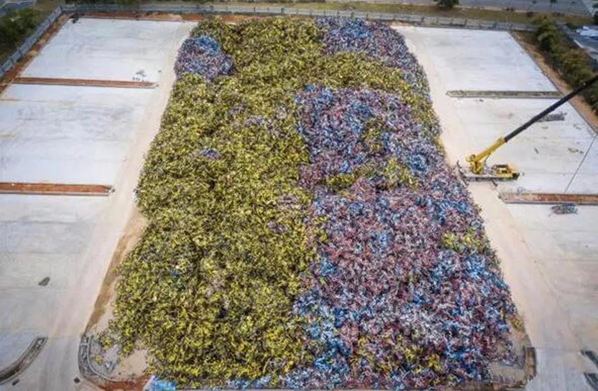  这是在厦门一处安置被收缴单车的“坟墓”，由于场地太小容纳不了如此数量的单车，所以启用了起重机来积压放置。（互联网） 