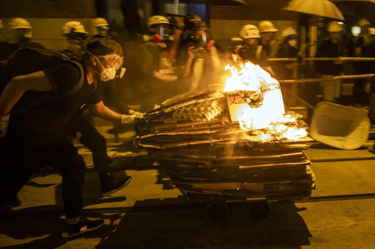  在7月28日香港上环的一场抗争中，示威者自制“火焰冲车”撞向警队防线。（彭博社） 