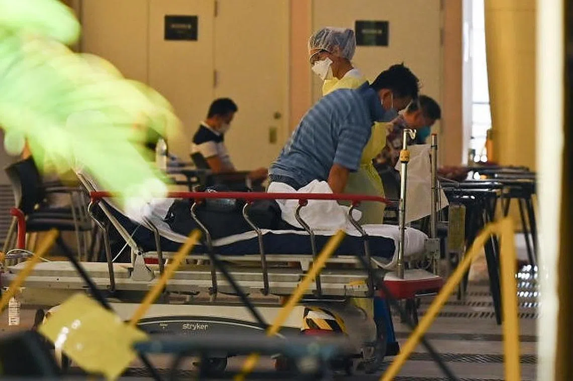 各大医院与诊所人手吃紧，除了要看护更多患者，不定时加班加点，就连休假日也无法放松，被院方紧急召回服务。图为陈笃生医院。（海峡时报）