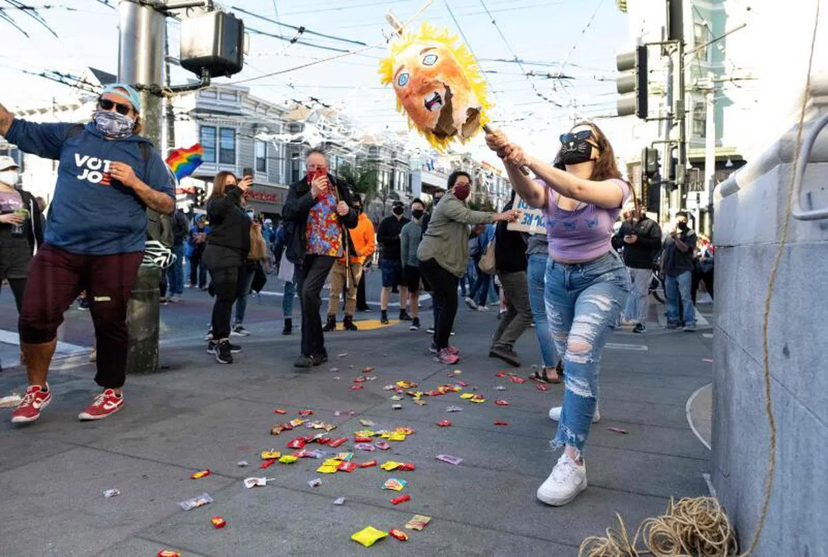  一名女生为了庆祝拜登当选总统，砸碎了特朗普人形的皮纳塔。（法新社） 