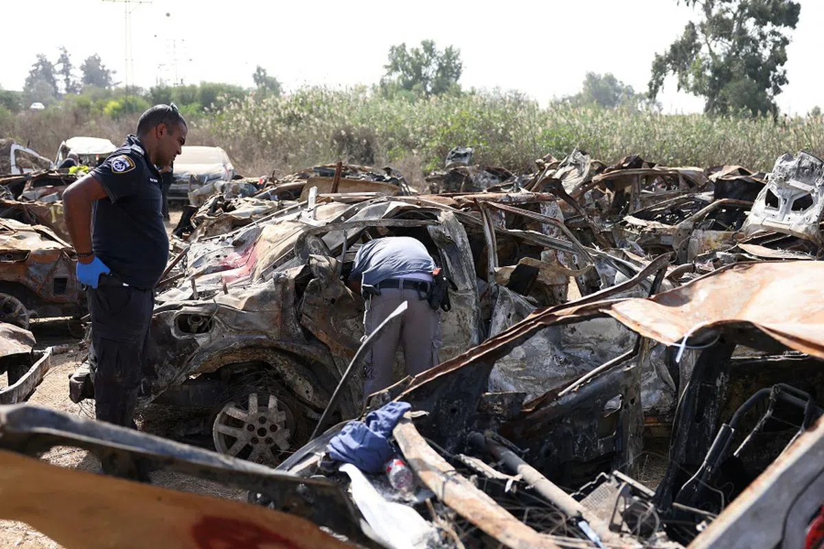 以色列搜救人员在哈马斯10月7日突袭现场寻找罹难者遗骸和其他证物。（路透社）