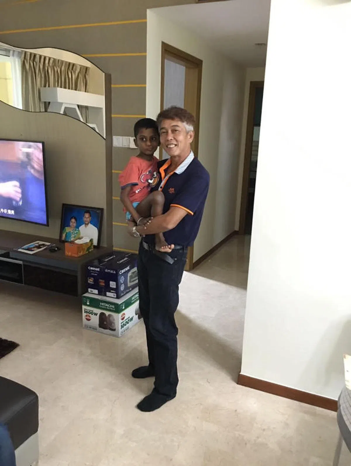  洪亚镇抱着玛尼的小儿子阿里仕 